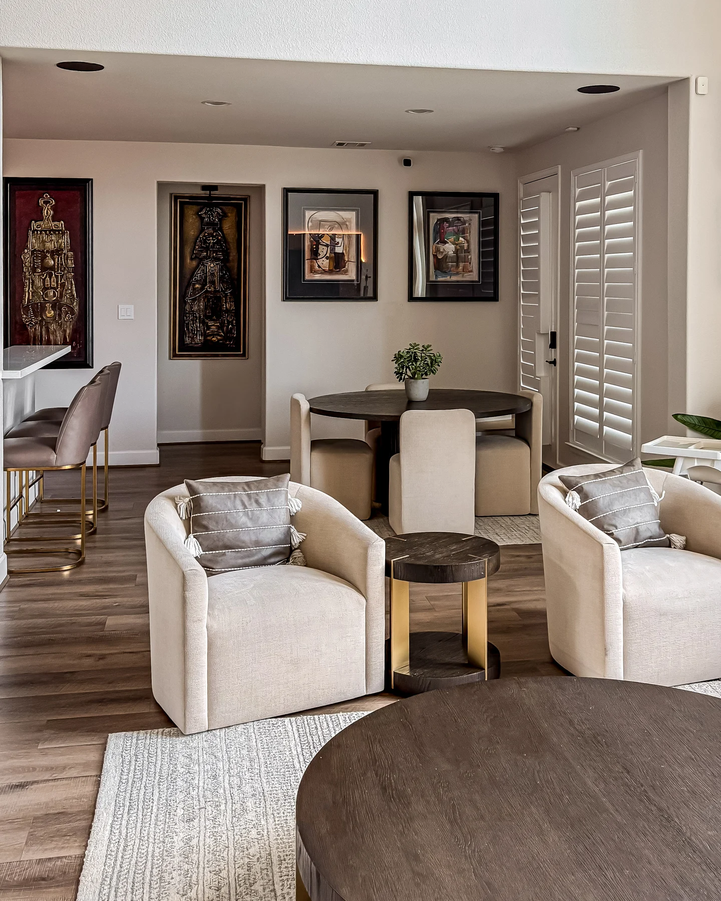 A sitting and dining room hung with framed works